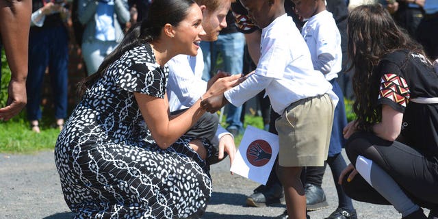 Prince Harry and Meghan Duchess of Sussex greet children on their arrival at the Nyanga Methodist Church in Cape Town, South Africa, in Sept. 2019.