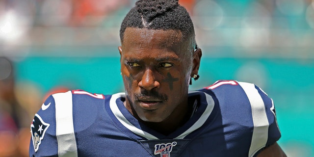 In this Sunday, Sept. 15, 2019, photo, New England Patriots wide receiver Antonio Brown waits for the team's NFL football game against the Miami Dolphins to begin in Miami Gardens, Fla. Brown was released by the Patriots on Friday, Sept. 20, after a second woman accused him of sexual misconduct. (David Santiago/Miami Herald via AP)
