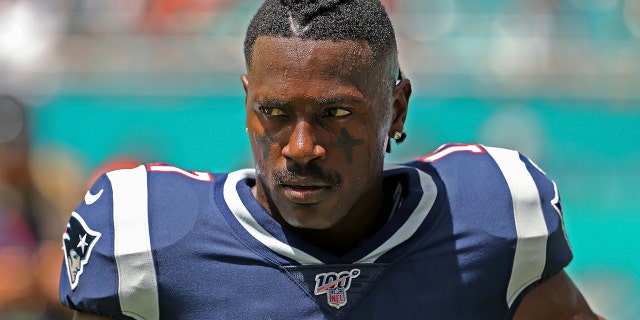 In this Sunday, Sept. 15, 2019, photo, New England Patriots wide receiver Antonio Brown waits for the team's NFL football game against the Miami Dolphins to begin in Miami Gardens, Fla. Brown was released by the Patriots on Friday, Sept. 20, after a second woman accused him of sexual misconduct. (David Santiago/Miami Herald via AP)