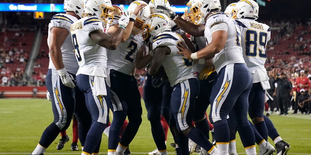 Los Angeles Chargers running back Derrick Gore, center, celebrates with teammates after scoring against the San Francisco 49ers during the second half of an NFL preseason football game in Santa Clara, Calif., Thursday, Aug. 29, 2019. (AP Photo/Tony Avelar)