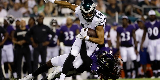 Philadelphia Eagles' JJ Arcega-Whiteside (19) is tackled by Baltimore Ravens' Maurice Canady (26) during the first half of a preseason NFL football game Thursday, Aug. 22, 2019, in Philadelphia. (AP Photo/Michael Perez)