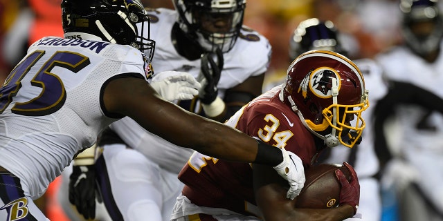 Washington Redskins running back Byron Marshall (34) carries the ball despite pressure from Baltimore Ravens linebacker Jaylon Ferguson (45) during the first half of an NFL preseason football game at FedEx Field in Landover, Md., Thursday, Aug. 29, 2019. (AP Photo/Susan Walsh)