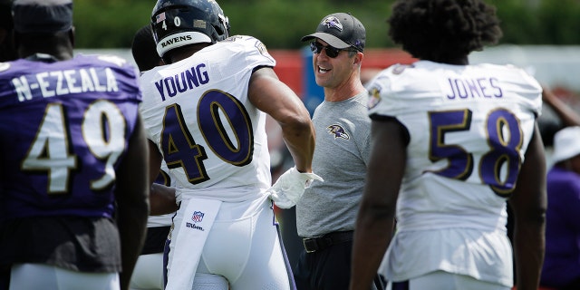 Baltimore Ravens head coach John Harbaugh meets with players during a joint NFL football practice with the Philadelphia Eagles in Philadelphia, Tuesday, Aug. 20, 2019. (AP Photo/Matt Rourke)