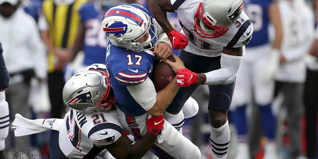 New England Patriots defenders Jonathan Jones (31) and New England Patriots Duron Harmon (21) tackle Buffalo Bills quarterback Josh Allen (17) in the second half of an NFL football game, Sunday, Sept. 29, 2019, in Orchard Park, N.Y. Allen left the field after the play. (AP Photo/Ron Schwane)