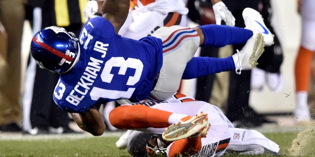 FILE - In this Aug. 21, 2017, file photo, New York Giants wide receiver Odell Beckham (13) is tackled by Cleveland Browns strong safety Briean Boddy-Calhoun in the first half of an NFL preseason football game in Cleveland. (AP Photo/David Richard, File)