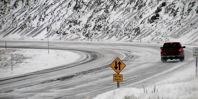 A motorist travels along U.S. 287 near Norris, Mont. during a snowstorm on Sunday.
