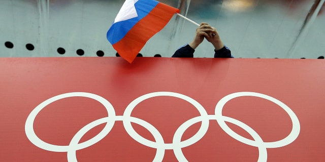 FILE - In this Feb. 18, 2014 file photo, a Russian skating fan holds the country's national flag over the Olympic rings before the men's 10,000-meter speedskating race at Adler Arena Skating Center during the Winter Olympics in Sochi, Russia. A person familiar with the case tells The Associated Press that Russia's anti-doping agency could face suspension again based on information indicating data from the Moscow drug-testing lab had been manipulated before being delivered to the World Anti-Doping Agency earlier this year. (AP Photo/David J. Phillip, File)