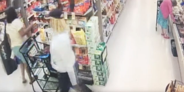 The video of the robbery shows the thief slowly slipping his hand into the woman's handbag as she turns her back and grabs what appears to be a wallet under the eyes of her alleged accomplice. The two men then left.