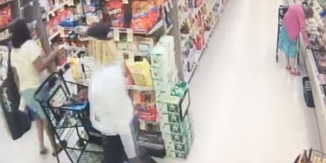 The video of the robbery shows the thief slowly slipping his hand into the woman's handbag as she turns her back and grabs what appears to be a wallet under the eyes of her alleged accomplice. The two men then left.