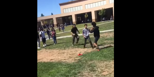 A U.S. Marine sprints to tackle two high school students in Stockton, Calif., to break up their fight. (Courtesy of 209 Times)