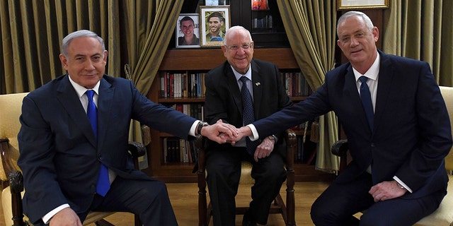 After a meeting with Israel's President Reuven Rivlin, center, Prime Minister Benjamin Netanyahu, left, and Blue and White party leader Benny Gantz agreed to begin talks toward forming a unity government.