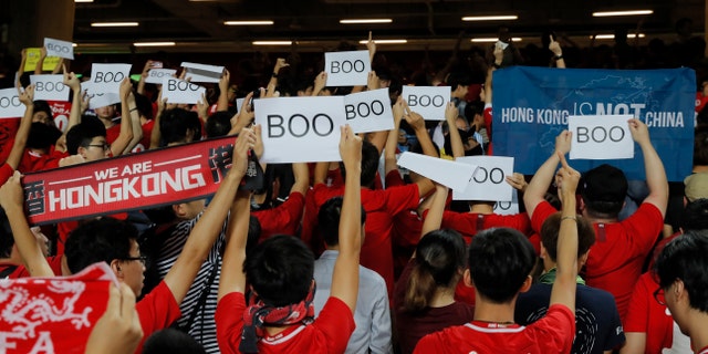 Hong Kong soccer fans turn their back and boo the Chinese national anthem as they chant "Hong Kong is not China" during the FIFA World Cup Qatar 2022 and AFC Asian Cup 2023 Preliminary Joint Qualification Round 2 soccer match between Hong Kong and Iran. (AP Photo/Kin Cheung)