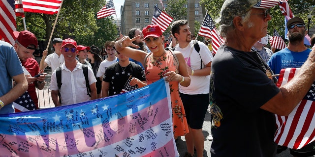 A transgender Trump supporter, center, marches in the Straight Pride Parade in Boston, Saturday, Aug. 31, 2019. (AP Photo/Michael Dwyer)