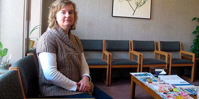 In this Feb. 20, 2013, photo, Tammi Kromenaker, director of the Red River Valley Women's Clinic, North Dakota's sole abortion provider, sits in the waiting area of the facility in Fargo, N.D. (AP Photo/Dave Kolpack, File)