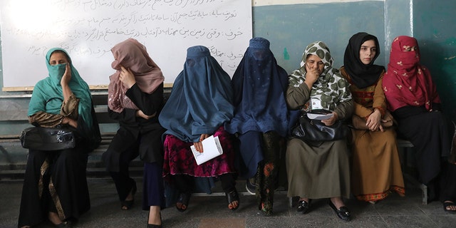 Afghan women wait for the a polling station to open in Kabul, Afghanistan, Saturday, Sept. 28, 2019. Afghans headed to the polls on Saturday to elect a new president amid high security and Taliban threats to disrupt the elections, with the rebels warning citizens to stay home or risk being hurt. (AP Photo/Ebrahim Nooroozi)
