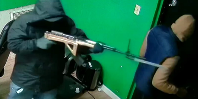 Surveillance image of a robber with an SKS rifle with a bayonet at the Green Galaxy Smoke Shop in Bradenton on Wednesday.