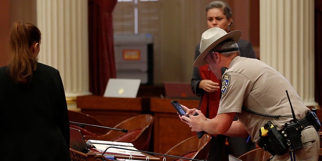 A California traffic police officer photographed an office on the floor of the Senate after a red liquid was thrown from the Senate tribune at the Senate sitting on Capitol Hill in Sacramento, California on Friday. September 2019. (Associated Press)