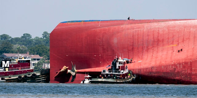 Rescuers work near the stern of the vessel Golden Ray as it lays on its side near the Moran tug boat Dorothy Moran, Monday, Sept. 9, 2019, in Jekyll Island, Ga.