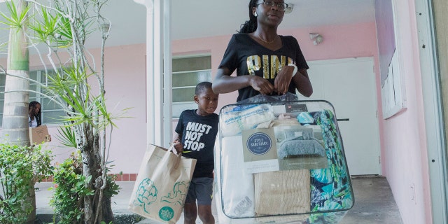 Volunteers Sanai Clark, 14, and Elliot Mirutil, 7, bringing items to be donated to the Bahamas at Christ Episcopal Church in Miami on Tuesday. (AP Photo/Ellis Rua)