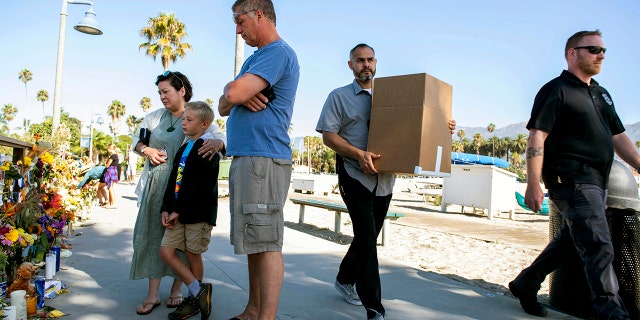 People gather around a memorial for the victims of the Conception dive boat fire on the Santa Barbara Harbor in Santa Barbara, Calif., Sunday, Sept. 8, 2019. . (AP Photo/ Christian Monterrosa)