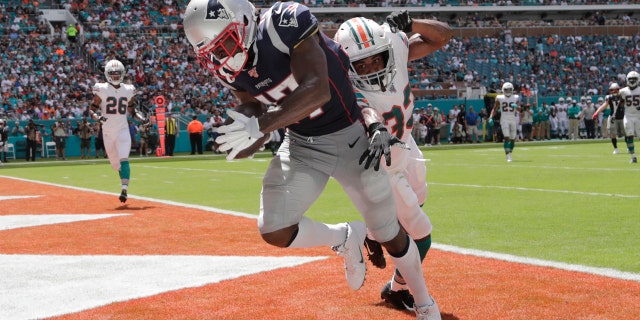 New England Patriots wide receiver Antonio Brown (17) scores a touchdown as Miami Dolphins cornerback Jomal Wiltz (33) attempts to defend, during the first half at an NFL football game, Sunday, Sept. 15, 2019, in Miami Gardens, Fla.