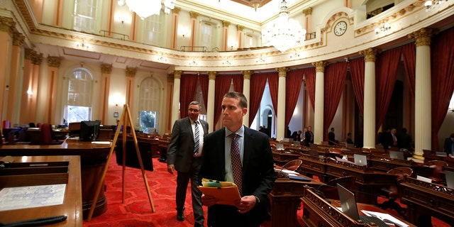 State Senator Mike McGuire of D-Healdsburg, right, leaves the Senate rooms after a red substance was thrown from the Senate tribune during the Senate sitting at the Capitol in Sacramento, California, Friday, September 13, 2019. (AP Photo / Rich Pedroncelli)