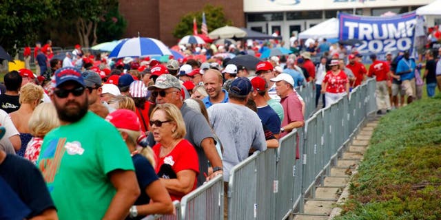 Attendees line up outside hours before President Donald Trump speaks at a campaign rally in Fayetteville, N.C., Monday Sept. 9, 2019 (AP Photo/Chris Seward)