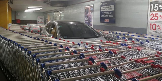 A grey Peugeot 308 parked incorrectly at an Argentina supermarket was closed off by shopping carts.