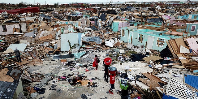 People search for salvageable items as they make their way through an area destroyed by Hurricane Dorian at Marsh Harbour in Great Abaco Island, Bahamas on Thursday.