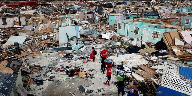 People search for salvageable items as they make their way through an area destroyed by Hurricane Dorian at Marsh Harbour in Great Abaco Island, Bahamas on Thursday.