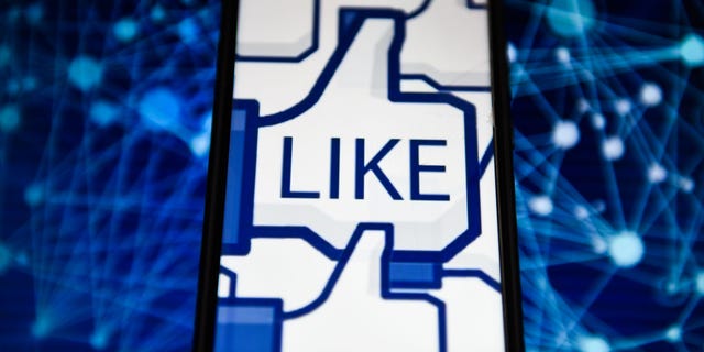   Facebook-like logo is seen displaying on an Android mobile phone. The tech giant is experimenting with hiding the likes of Australia. 