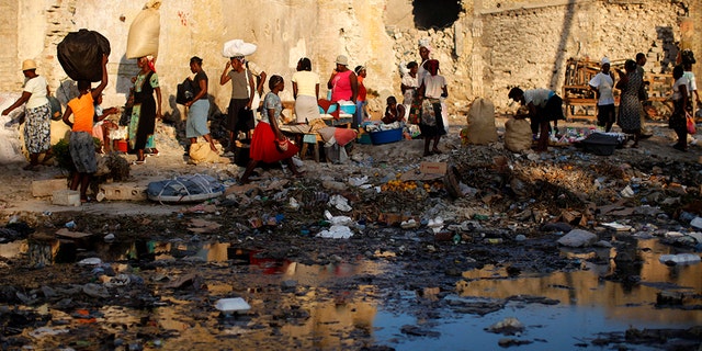 Haitians make their way through a puddled street in Port-au-Prince November 19, 2010.