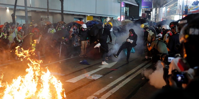 Protesters kicked back an exploded tear gas shell at police officers during a pro-democracy protest in causeway bay over the weekend. (AP Photo/Kin Cheung)