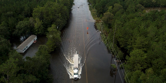 A truck drives on a flooded highway as the remains of tropical storm Imelda continue in southeast Texas on Friday, September 20, 2019 in Mauriceville, Texas. (Jon Shapley / Houston Chronicle via AP)