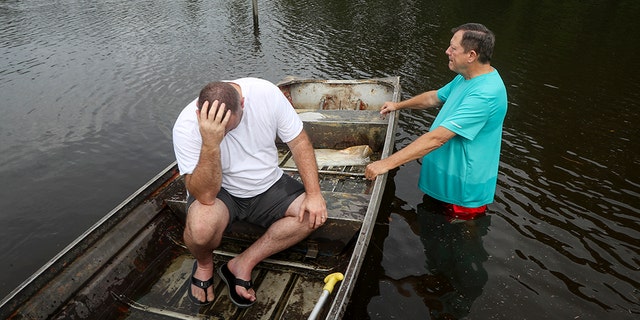 Stephen Gilbert, left, and his father-in-law sit in front of their flooded property on Friday, September 20, 2019 in the Mauriceville, Texas area. The floodwaters are beginning to retreat into most of the Houston area after flooding remnants of tropical storm Imelda in parts of Texas. "I'm at my third home," said Gilbert, who lives behind his father-in-law. "I would not go anywhere else in the world," he said. "Anyway, we only have family." (Jon Shapley / Houston Chronicle via AP)