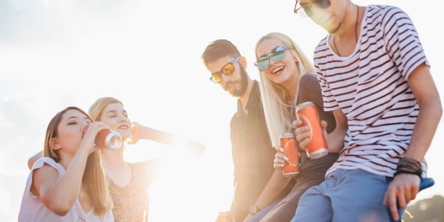 A group drinking tallboy cans, while possibly on vacay.