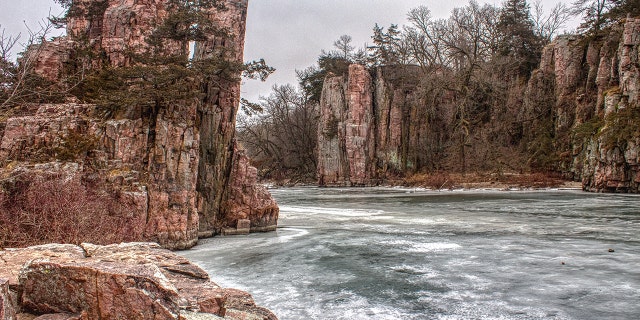 A woman survived falling down a cliff in South Dakota's Palisades State Park, officials said.