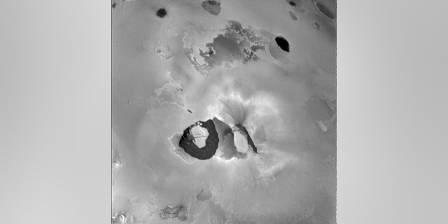 This picture from Voyager 1 shows the volcano Loki on Jupiter’s moon Io. When this picture was taken, the main eruptive activity came from the lower left of the dark linear feature (perhaps a rift) in the center. Below is the "lava lake," a U-shaped dark area about 200 kilometers across. (Credit: NASA/JPL)