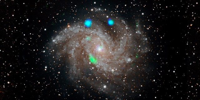 This visible-light image of the Fireworks galaxy (NGC 6946) comes from the Digital Sky Survey, and is overlaid with data from NASA's NuSTAR observatory (in blue and green). Credit: NASA / JPL-Caltech