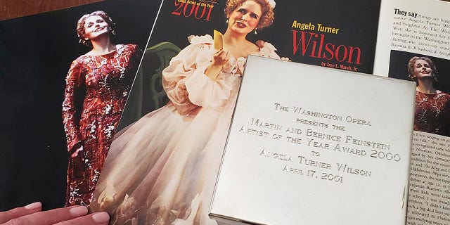 Opera singer Angela Turner Wilson displays her 2000 Artist of the Year award from the Washington Opera next to a photo of herself from a 1999 performance of "Le Cid," left, and a magazine article in a Washington Opera magazine, at her home in Texas.