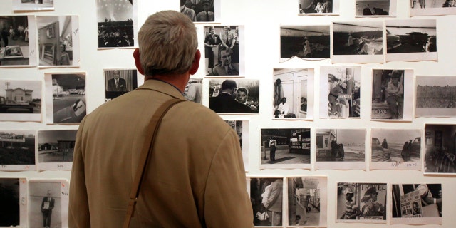 In this May 18, 2009 file photo, a man looks at prints from the Looking In: Robert Frank's "The Americans" exhibit at the Museum of Modern Art in San Francisco.