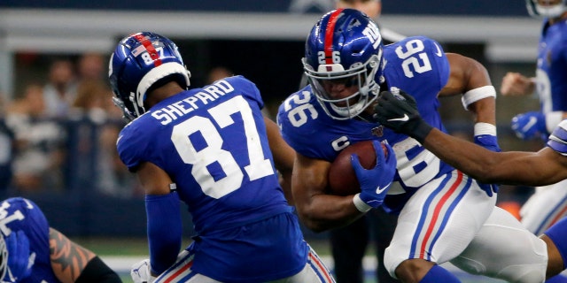 New York Giants' Sterling Shepard (87) helps clear running room for running back Saquon Barkley (26) as Dallas Cowboys cornerback Byron Jones (31) defends in the second half of an NFL football game in Arlington, Texas, Sunday, Sept. 8, 2019. (AP Photo/Michael Ainsworth)