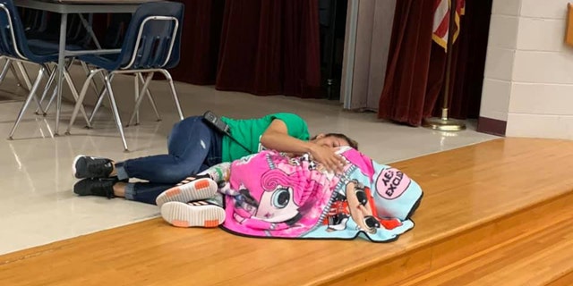Ms. Esther climbed up on stage and laid next to a student who was struggling with the noisy cafeteria.