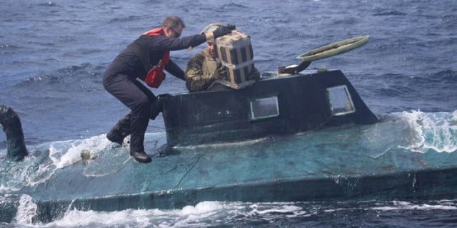 U.S. Coast Guard boarding team members climb aboard the suspected smuggling vessel