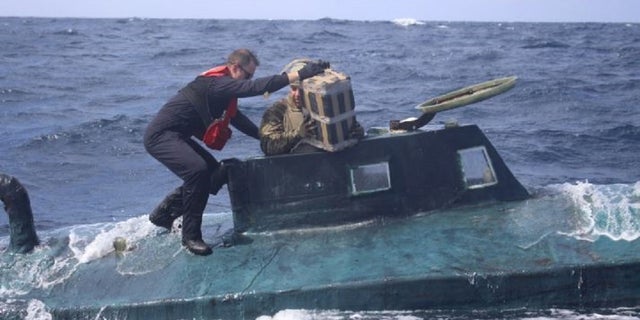 U.S. Coast Guard boarding team members climb aboard the suspected smuggling vessel