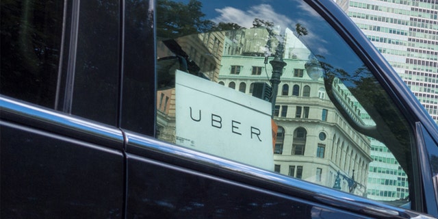 Close up of Uber car service sign in car window.  