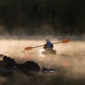 A kayaker paddles through the morning mist on Pigeon Lake in central Ontario, Sept. 17, 2019. 