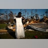 Synopsis Reckley holds up the dress her niece wore as a flower girl at her wedding, as she goes through valuables in the rubble of her home destroyed by Hurricane Dorian in Rocky Creek East End, Grand Bahama, Bahamas, Sept. 8, 2019.?