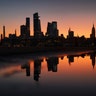 A man walks in front of the skyline of midtown Manhattan as the sun rises in New York City, Sept. 22, 2019.