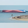 People are shown on Jekyll Island's Driftwood Beach as the Golden Ray cargo ship is capsized in the background, off the Georgia coast, Sept. 8, 2019.